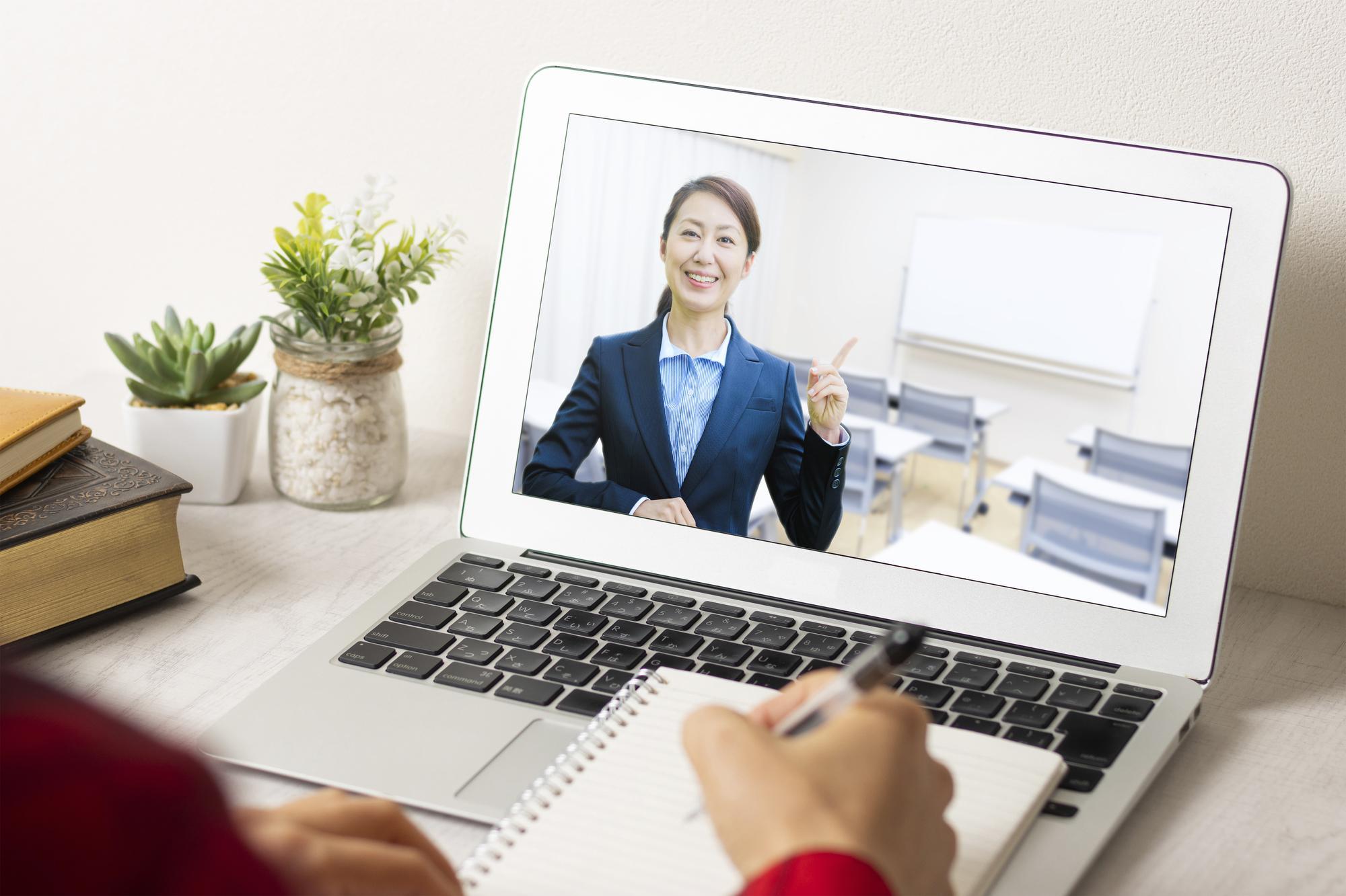 人さし指を立てて講義する女性が映るノートPCの画面