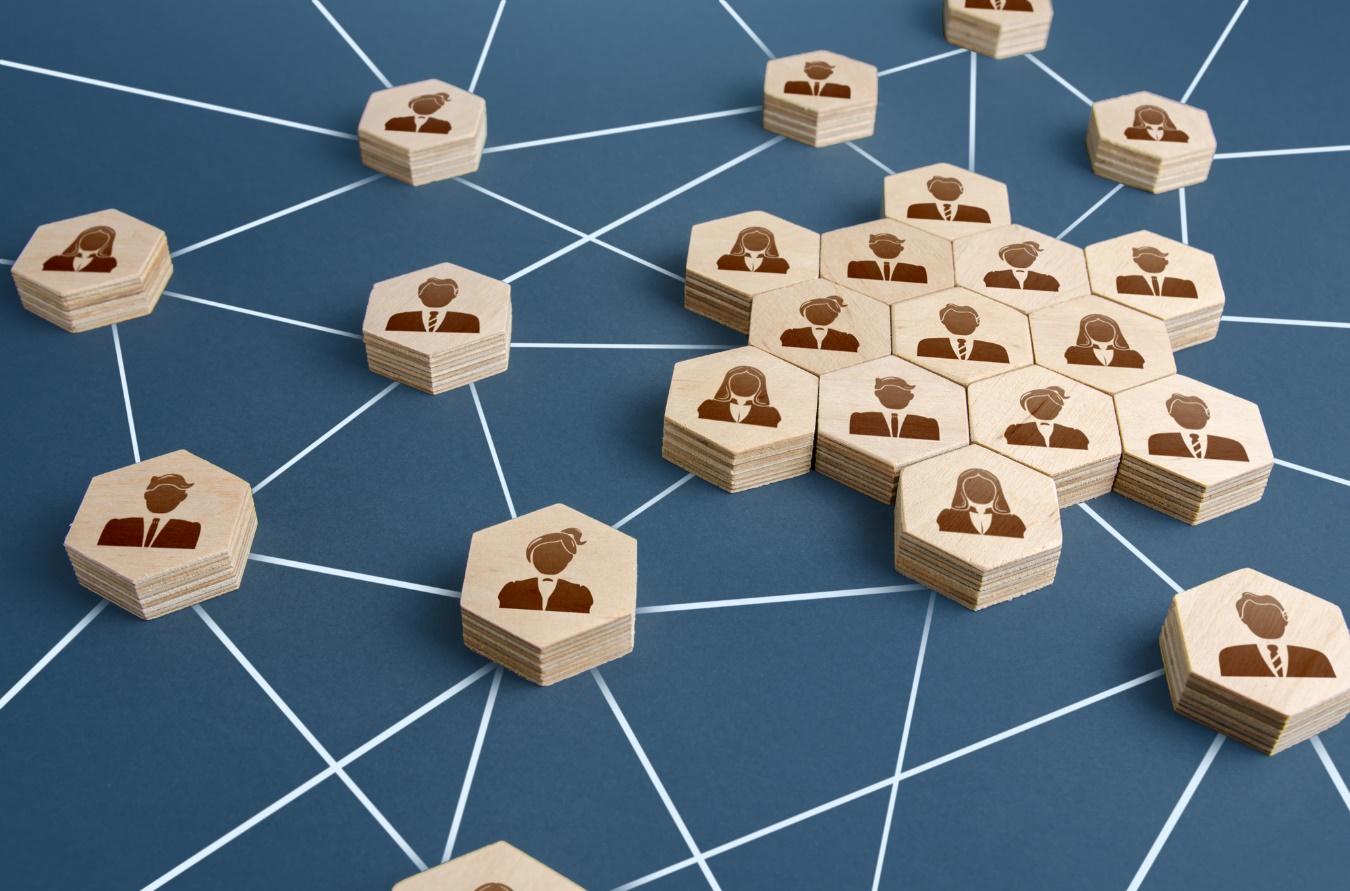 ビジネスパーソンのシンボルを描いた複数の木製ピースによる、組織内ネットワークのイメージ