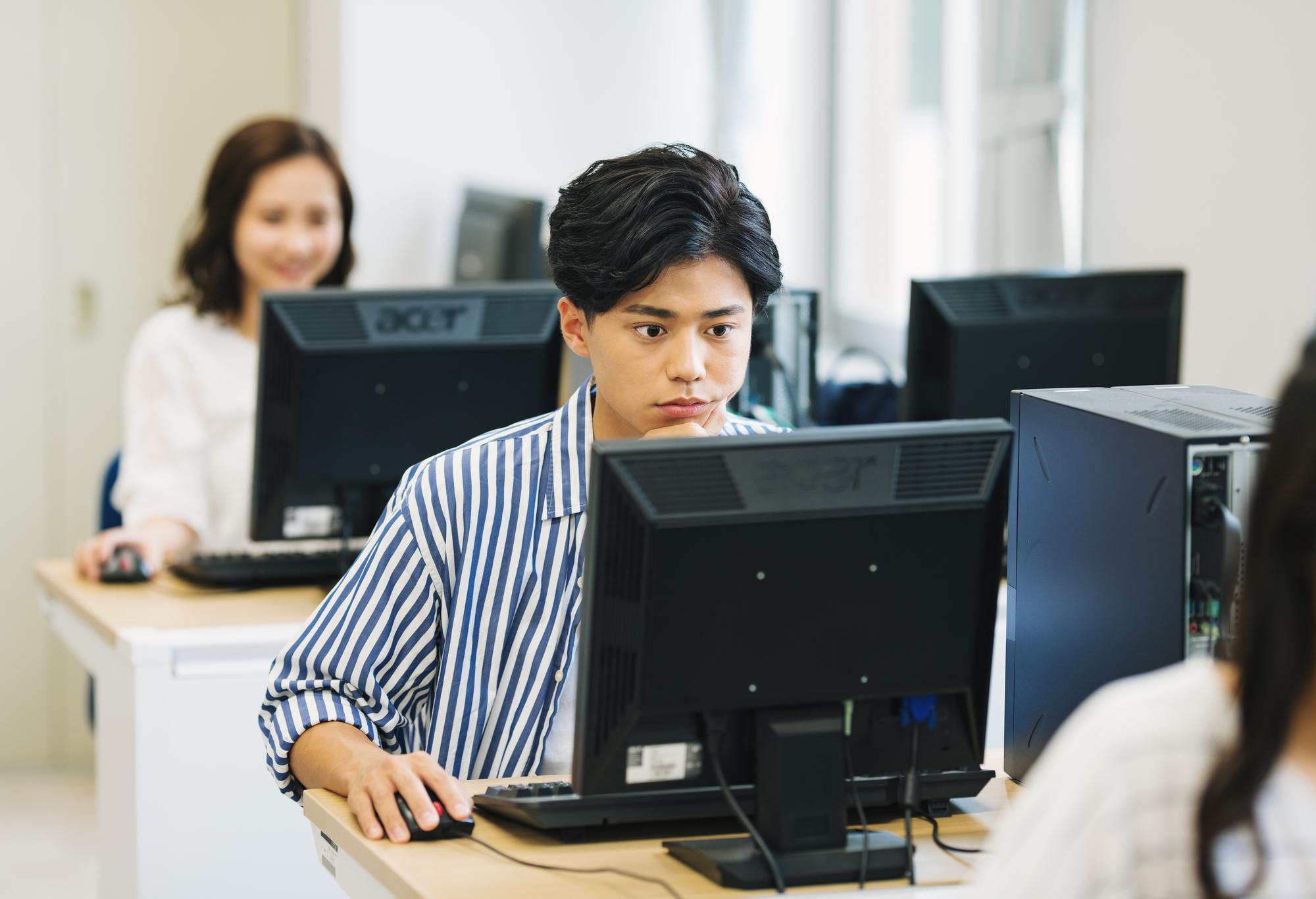 デバイス環境の整ったオフィスでAI活用を学ぶ若い男性